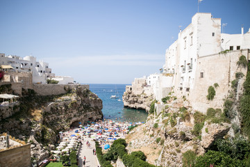Fototapeta na wymiar Beautiful beach with people in Polignano a Mare in the southern part of Italy crystal clear azure water
