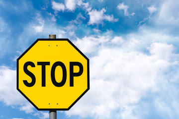 Yellow octagon road sign against blue sky