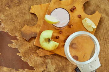 Yogurt with apple and nuts on a wooden background. Daylight.