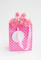 pink paper bag with bouquet of roses