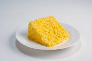 Gastronomy. Slice of the traditional corn couscous from northeastern Brazil, on a white plate