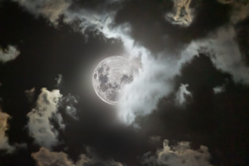 Obraz na płótnie Canvas luna de abril escondiendose y saliendo de entre medio de las nubes