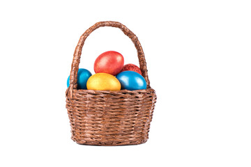 Basket with multi-colored Easter eggs isolated on a white background.