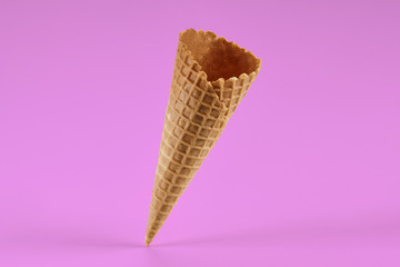Empty, tasty wafer cone for ice cream against pink background. Concept of food, treats. Mockup,...