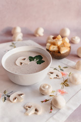 Fototapeta na wymiar creamy mushroom cream soup with champignons serving in delicate pink colors