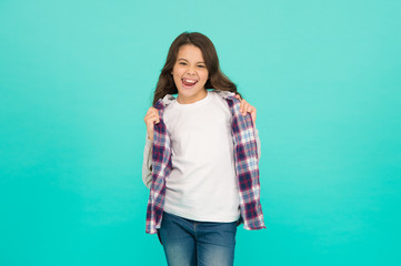 Fototapeta na wymiar Feeling cool. Cute girl with long hair. Small girl checkered shirt. Happy international childrens day. Little girl turquoise background. Good mood concept. Positive vibes. Fashion shop. Shopping day