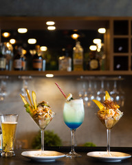 Two ceviche on martini glasses with cocktail and beer glass