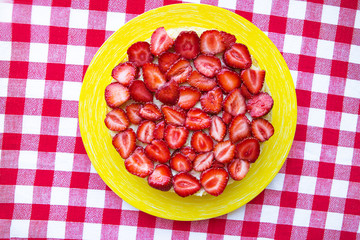Bright and delicious strawberry cake on a red napkin in a cage