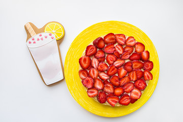 A bright and tasty strawberry cake stands on the table along with cookies in the form of a cocktail