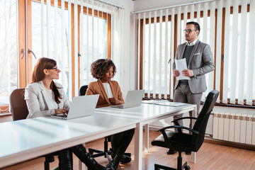 Confident man discussing with colleagues in the boardroom