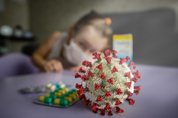  Scared masked little girl sitting around with the Covid-19 virus waiting for the cure. Coronovirus Treatment