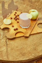 Yogurt with apple and nuts on a wooden background. Daylight.