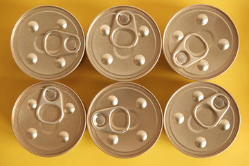 Canned food closed on yellow background. Top view. Copy, empty space for text