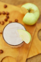 Yogurt with apple and nuts on a wooden background. Daylight.