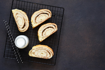 Bun with nuts and milk on a concrete background.