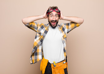 young housekeeper man looking happy, carefree, friendly and relaxed enjoying life and success, with...