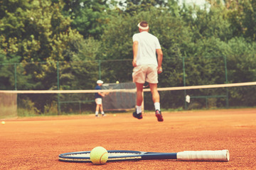 Men playing tennis match.