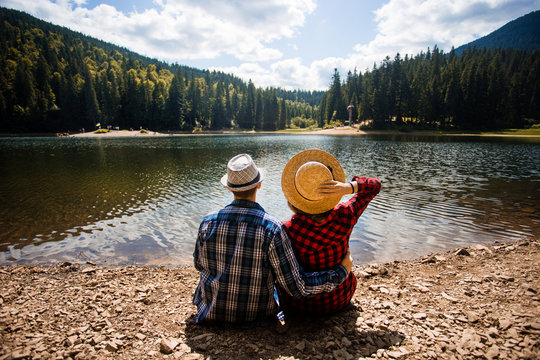 Travelers couple admire view of mountain lake. Travel and active life concept.