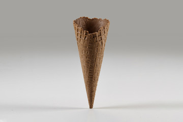 Empty, sweet, brown wafer cone for ice cream isolated on white. Concept of food, treats. Mockup, template for advertising and design. Close up