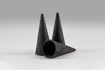 Three empty, tasty, black wafer cones for ice cream isolated on white. Concept of food, treats....