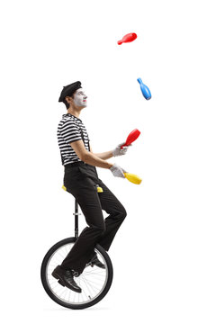 Pantomime guy riding a mono-cycle and juggling