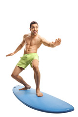 Young fit man surfing on a surfboard