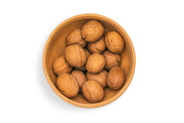 Walnuts in a wooden plate isolated on white background. Ripe walnut kernels close-up.