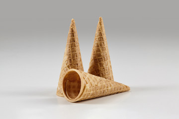 Three empty, tasty wafer cones for ice cream isolated on white. Concept of food, treats. Mockup, template for your advertising and design. Close up