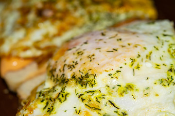 sandwiches with fried eggs with dill and sauce on wheat bread. Close up.