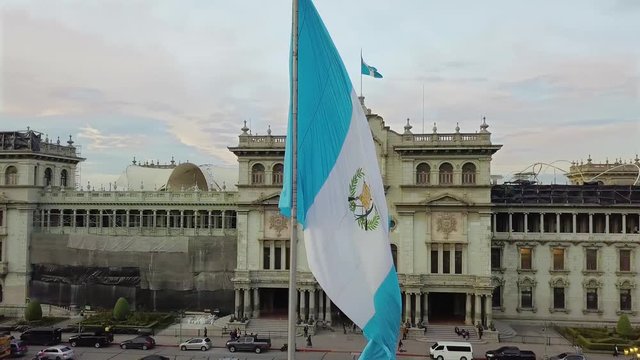 An aerial shot of the historic Parque Centenario in Zone 1 of Guatemala city with the national flag waving at golden hour. 