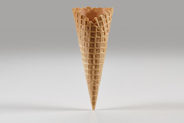 Empty, crispy wafer cone for ice cream isolated on white. Concept of food, treats. Mockup, template for your advertising and design. Close up