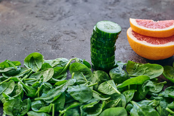 spinach, cucumber and grapefruit on a brown background