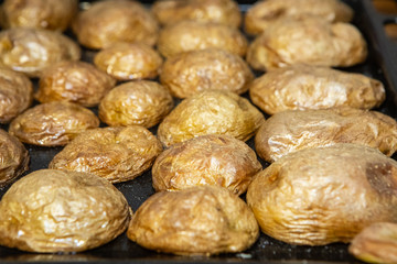 Delicious cooked potatoes with peel served on a tray. Vegan cuisine