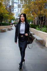 Beautiful Chinese Asian woman in fashionable business attire is enjoying a nice day walking around...