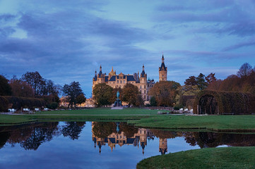 Fototapeta na wymiar Blue hour at Schwerin Castle that is reflected in the water. Mecklenburg-Vorpommern, Germany
