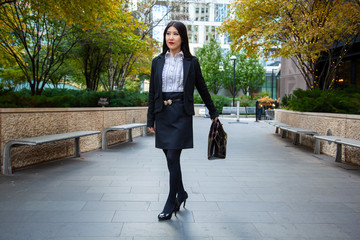 Beautiful Chinese Asian woman in fashionable business attire is enjoying a nice day walking around...