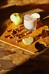 Yogurt with apple and nuts on a wooden background. Daylight.