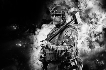 Portrait of a special forces soldier waving a sledgehammer to smash an obstacle. The concept of...