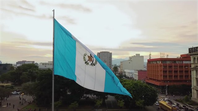 An aerial shot of the historic Parque Centenario in Zone 1 of Guatemala city with the national flag waving at golden hour. 