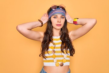 Young beautiful hippie woman with blue eyes wearing accesories and sunnglasses Doing bunny ears...