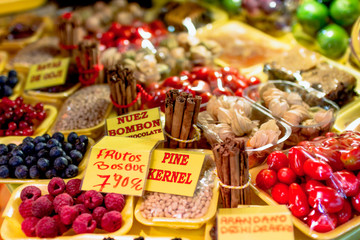 Fototapeta na wymiar Stand mit Himbeeren, Heidelbeeren, Tomaten, Pinienkernen und Zimstangen im .Mercado de Vegueta in Las Palmas auf der kanarischen Insel Gran Canaria