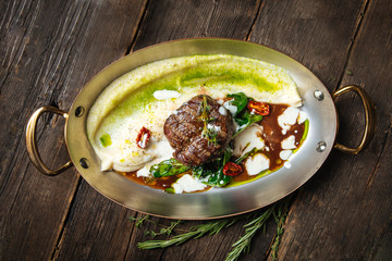 Top view on italian recipe cooked beef filet mignon with mashed potatoes and truffle sauce in a pan...