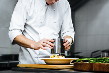 Restaurant chef cooking italian cuisine dish pasta fettuccine on the kitchen, horizontal format