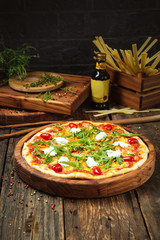 Side view on italian cuisine dish fresh cooked pizza with tomatoes, mozzarella cheese and arugula...