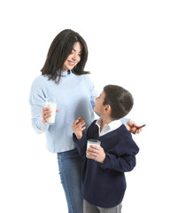 Mother and her little son drinking milk with cookies on white background