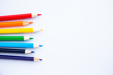 set of colored pencils on a white background with space for text