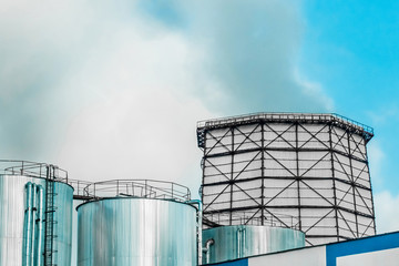 Cooling tower, desuperheater, smoke from a pipe of an industrial plant or thermal power plant on a background of blue sky
