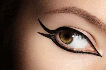 Beautiful Macro of Female Eye with Fashion Black Eyeliner Makeup. Perfect graphic Liner shape....