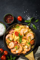 Pasta seafood with shrimp on black table.
