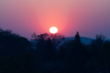 Sun during sunrise against the background of an orange sunset sky